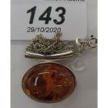 A silver and amber mounted pendant,