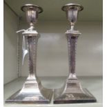 A pair of early 20thC silver candlesticks, each with square,