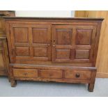 A George III oak chest with a pair of fielded panelled doors, over three in-line drawers,