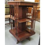 An Edwardian mahogany two tier revolving bookcase with slatted sides,