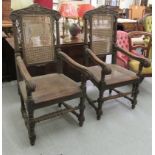A pair of late 19thC baronial style, oak framed, high back chairs with carved crests, side pillars,
