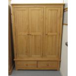 A modern Cotswold Oakley pine triple wardrobe with three panelled doors,