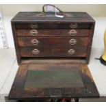 An early 20thC oak tool chest, the detachable front panel enclosing four drawers,