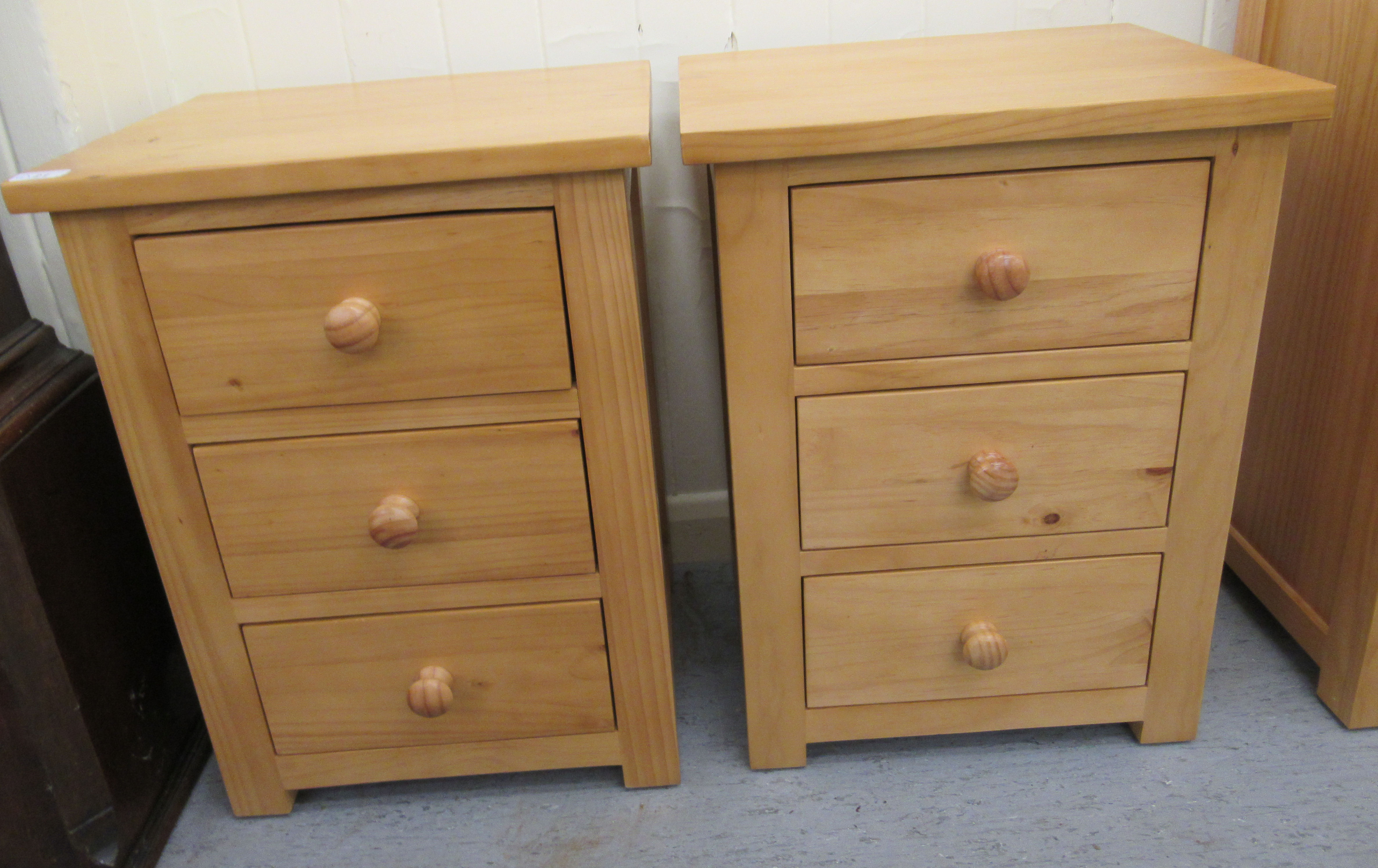 A pair of modern Cotswold Oakley pine three drawer bedside chests,