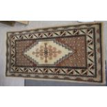 A Caucasian rug, decorated with repeating stylised designs,