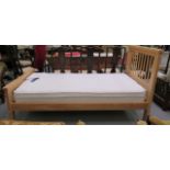 A modern Cotswold Oakley bleached pine single bed with a slatted headboard;