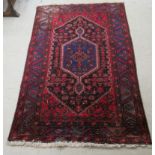 A Persian rug, decorated with repeating stylised designs,