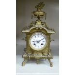 An early 20thC Continental decoratively cast brass cased mantel clock with an urn finial;