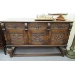 An early/mid 20thC Old English style stained oak sideboard with three frieze drawer,
