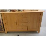 A modern beech sideboard with a central bank of five drawers, flanked by a pair of doors,