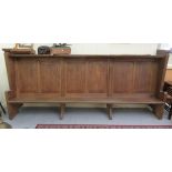 An early 20thC boarded light oak chapel pew, the canopied top acting as a lectern for those behind,