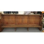 An early 20thC boarded light oak chapel pew, the canopied top acting as a lectern for those behind,