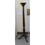 An early 20thC mahogany torchere, on a foliate carved,