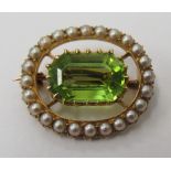 A Victorian yellow metal oval brooch/pendant, claw set with a peridot,