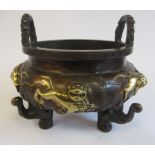 An Oriental cast and patinated and part gilded bronze censer, the bulbous bowl having opposing,