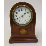 An early 20thC French round arched mahogany cased mantel timepiece with fan marquetry and satinwood