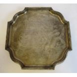 A silver salver with a raised border and in-curved corners,