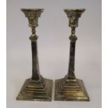 A pair of loaded silver bead bordered candlesticks, each having a detachable, incurved sconce,