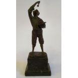 An early 20thC cold painted cast bronze standing figure, a young man eating grapes from his hat,