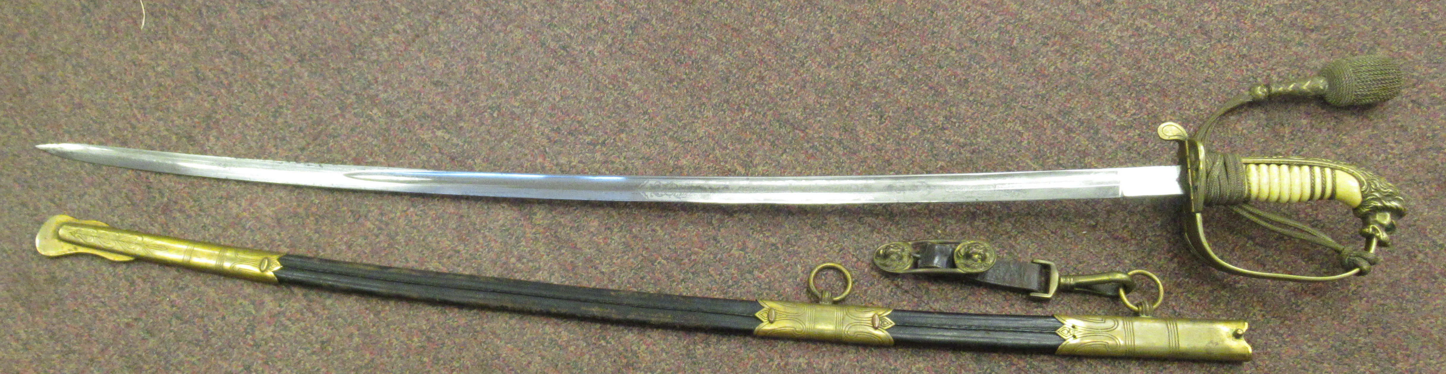 A German Imperial/Third Reich era naval officer's sword, having brass mounts, a lion's head pommel,