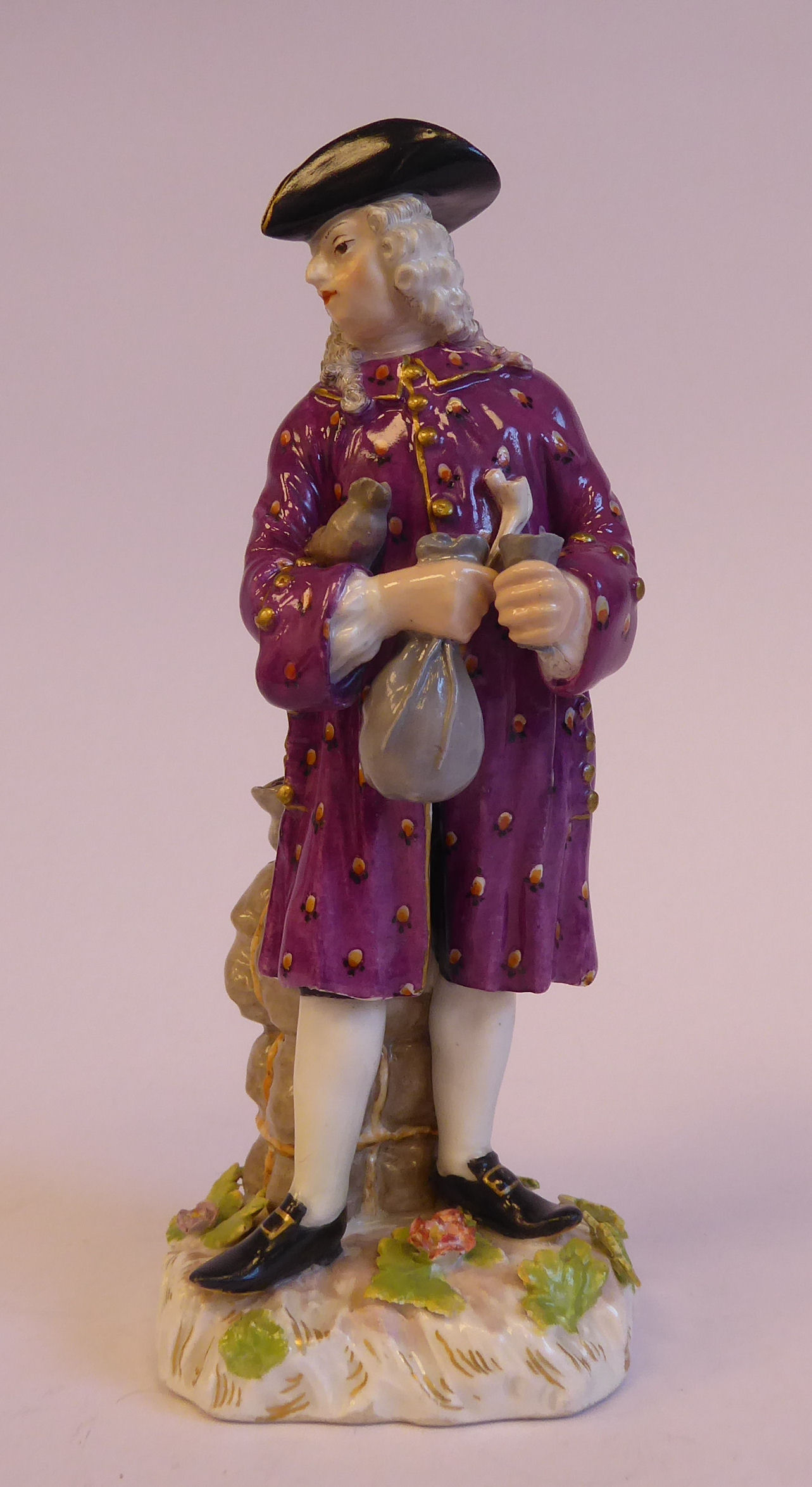 A mid 19thC Continental porcelain figure, a standing merchant, wearing a tricorn hat, wig,