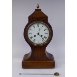 An early 20thC mahogany cased mantel clock of waisted balloon form with a four square,