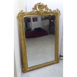 A late 19th/early 20thC overmantel mirror, set in a round arched,