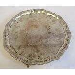A silver salver with a raised piecrust border, on scrolled feet Viners Sheffield 1940 10.