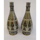 A pair of late Victorian Doulton Lambeth ovoid shaped stoneware bottle vases with applied silver