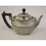 A late Victorian silver teapot of oval, demi-reeded form with a swept spout,