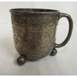 A late Victorian silver Christening cup, having a hollow loop handle, on ball feet,