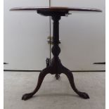 A 19thC mahogany tip-top pedestal table with marquetry fan ornament within a crossbanded and string