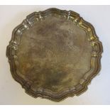 A late Victorian silver waiter with a raised piecrust border and an engraved vacant cartouche,