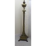 A late Victorian decoratively cast brass, square section lamp standard with a reservoir,