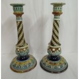 A pair of Doulton Lambeth blue, green and brown glazed stoneware candlesticks, decorated in moulded,