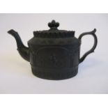 A 19thC black basalt oval teapot, having straight sides, an S-shaped spout, C-scrolled handle,