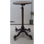 A late Victorian cast iron and brass reading table, the mahogany top raised on a height adjustable,