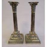 A pair of loaded silver candlesticks, each having a detachable bead bordered, incurved sconce,