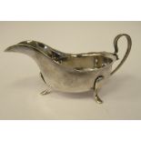 A silver sauce boat with a cut, flared rim and loop wire handle,