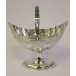 A George III Irish silver sugar basket of oval, flute moulded design, having a swing loop handle,