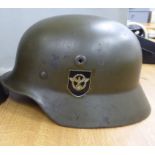 A German World War II design khaki painted military helmet with a hide lining,