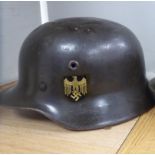 A German World War II design khaki painted military helmet with a hide lining,
