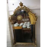 A modern reproduction of a 19thC mirror, set in a round arched, foliate scrolled and gilded frame,