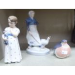 Three Royal Copenhagen porcelain figures, viz. a girl holding a doll no.