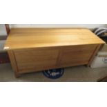 A modern pine chest with straight sides and a hinged lid, enclosing two drawers,