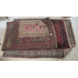 Four Persian and other rugs, mostly decorated with floral and foliate designs,