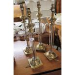 A set of four modern brushed brass and clear glass,