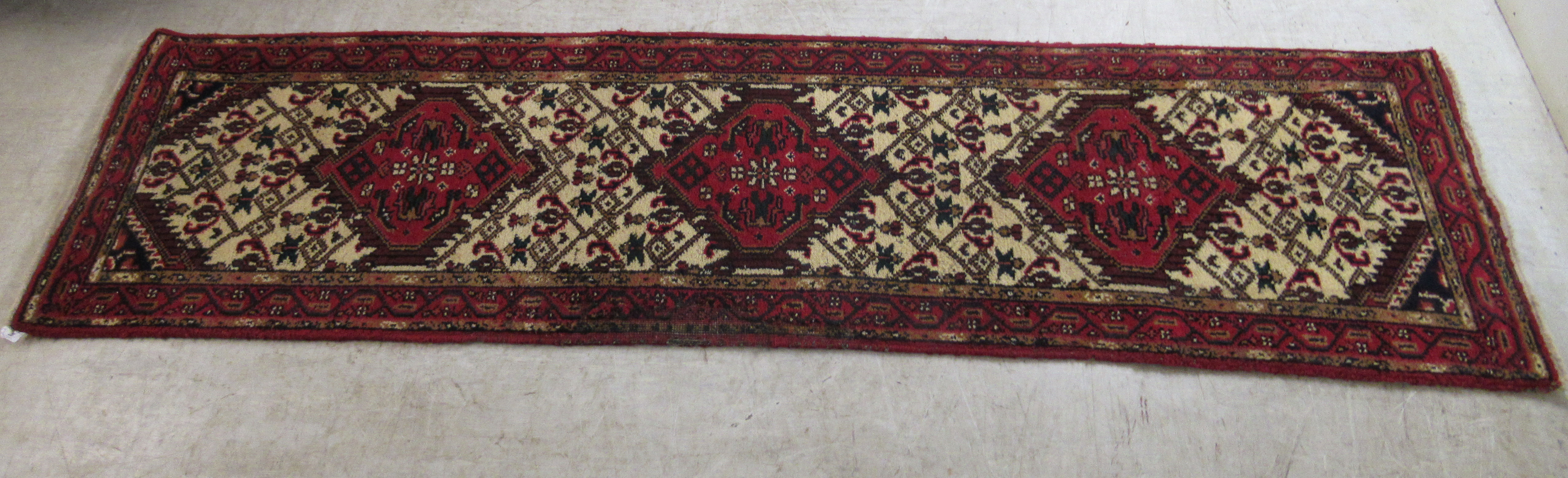 A Persian runner, decorated with three diamond shaped motifs,