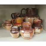Seven similar Doulton Lambeth and Royal Doulton two tone brown glazed stoneware jugs of bulbous