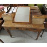 An early 20thC light oak dressing table, surmounted by a pivoting bevelled mirror,